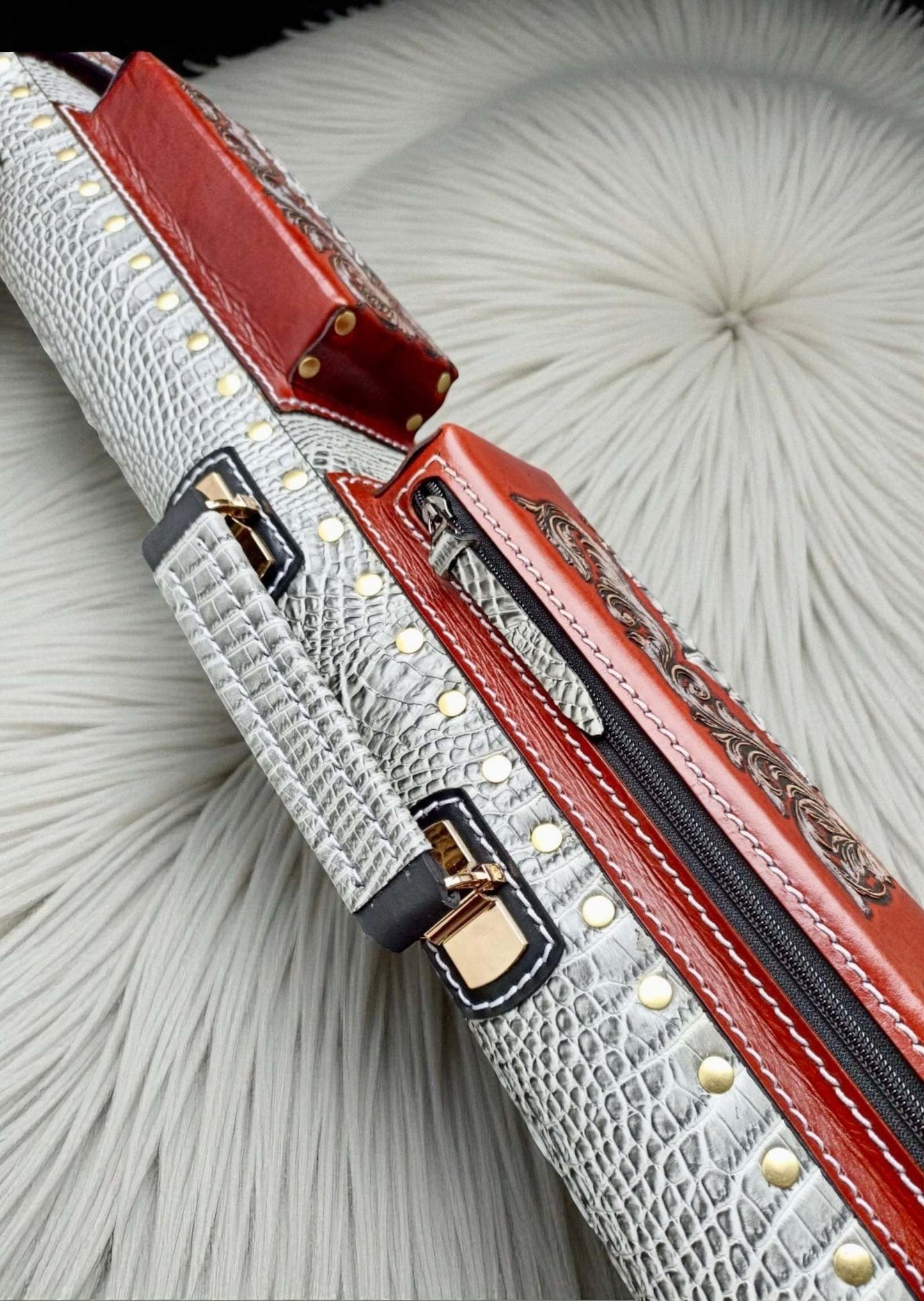 Side close-up view of the red orange Vicri vegetable-tanned cowhide cue case with a crocodile-embossed body.