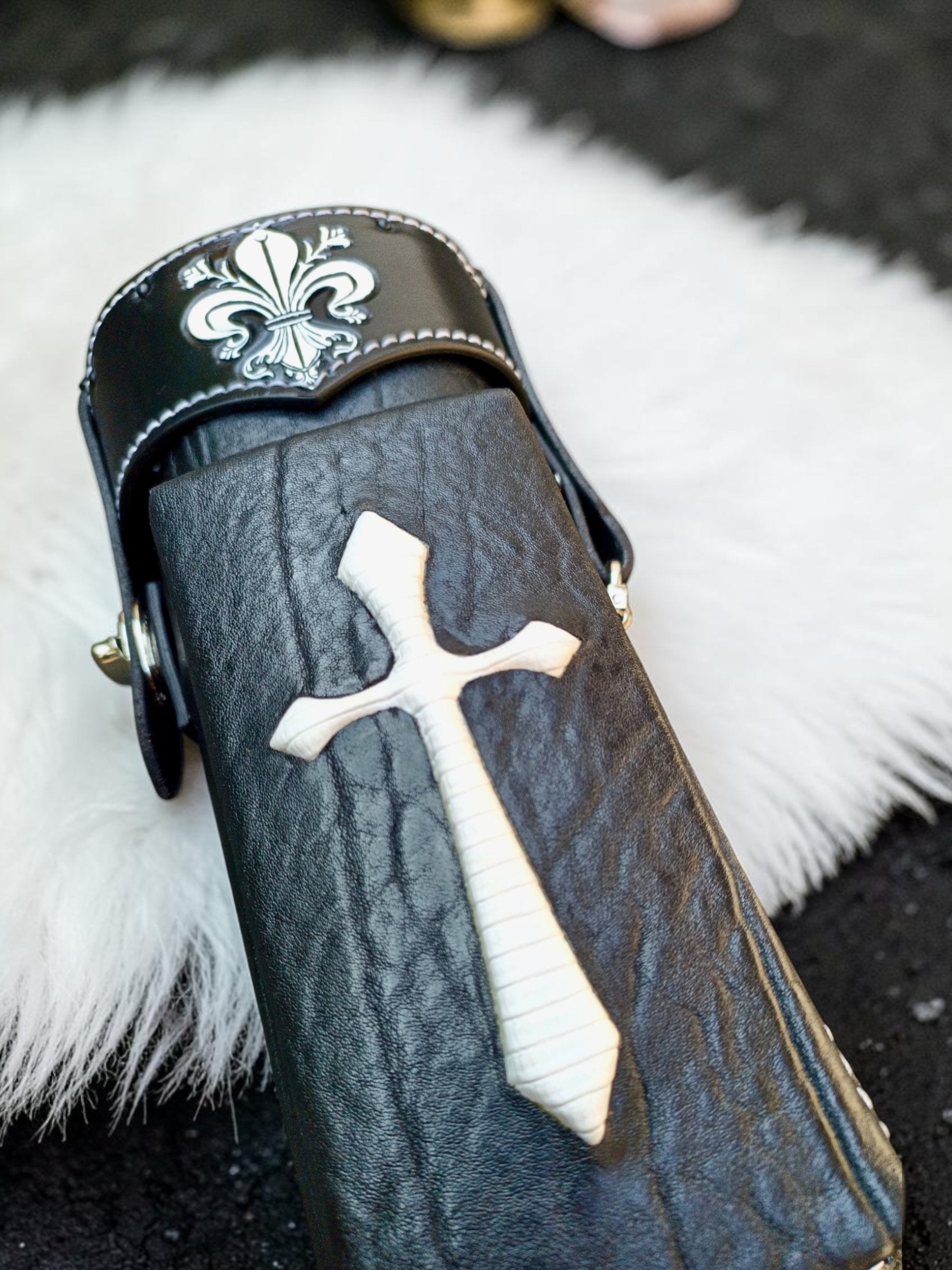Close-up of Crusade black leather cue case with white cross inlay, textured leather, and fine stitching