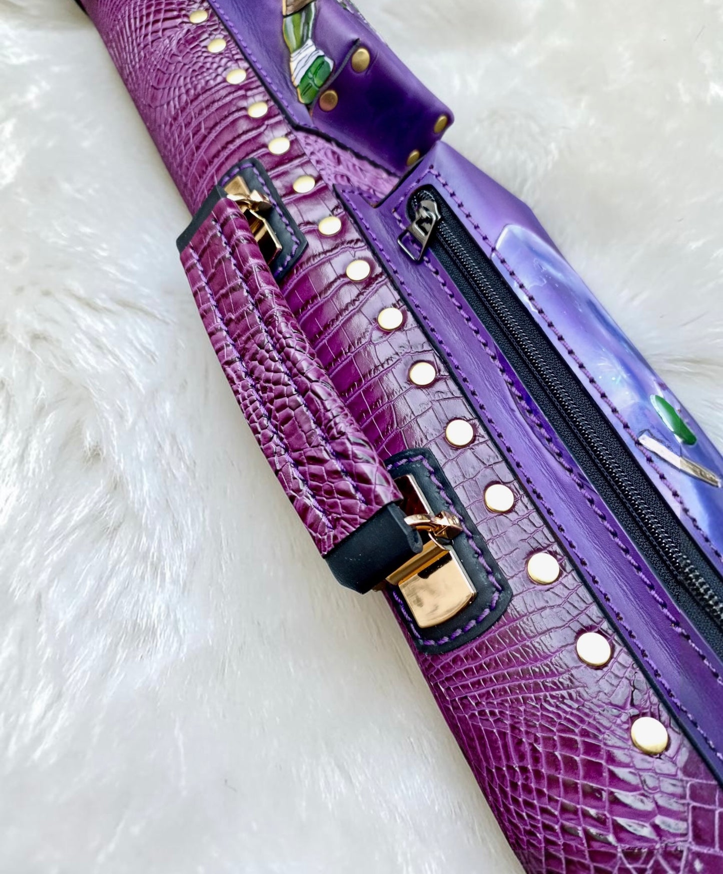Close-up of TMNT Donatello leather cue case handle, purple embossed leather and gold-tone hardware