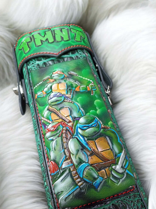 Close-up of TMNT leather cue case front with red mask detail and hand-tooled leather texture